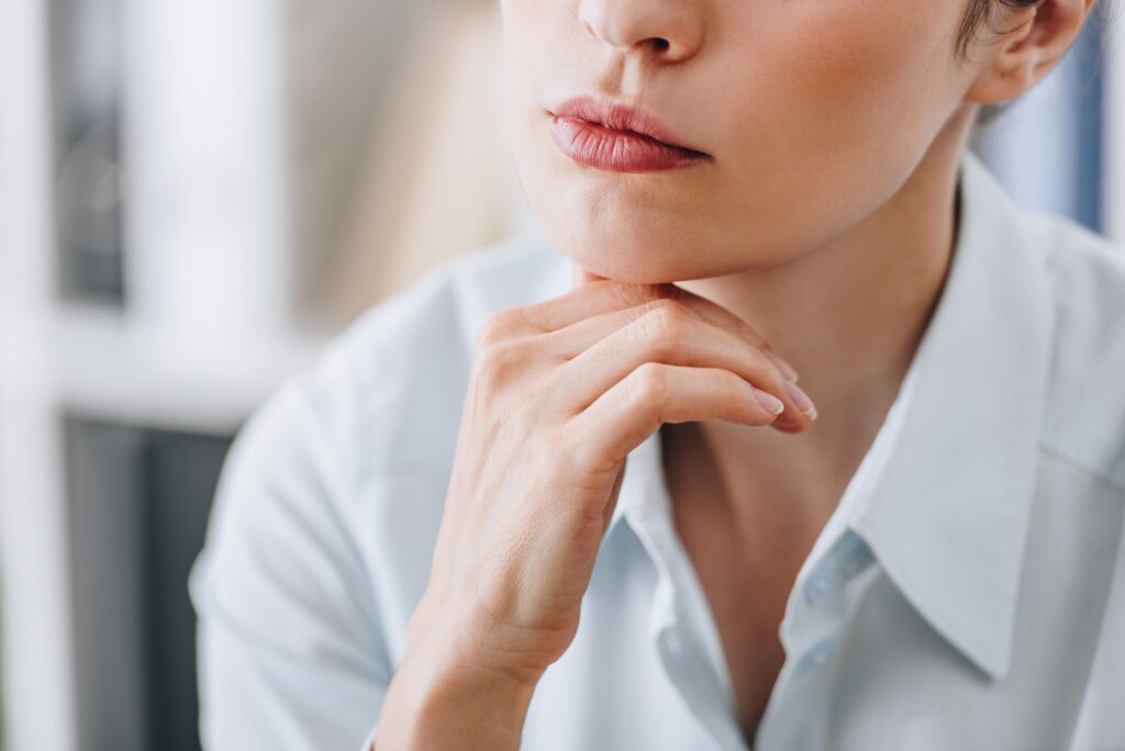 cropped shot of businesswoman touching chin with hand at office